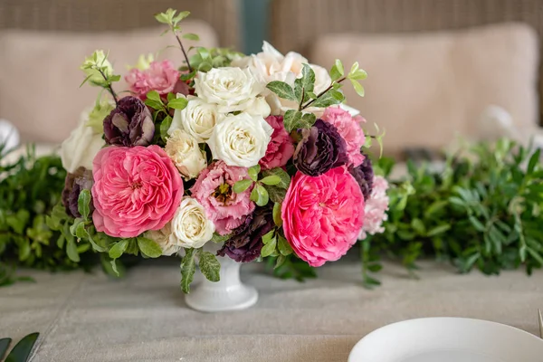 Arrangement of fresh flowers in pastel colors with a bright accent. Wedding background. table in a restaurant. different varieties of garden and shrub roses in a light vase on wooden table — Stock Photo, Image
