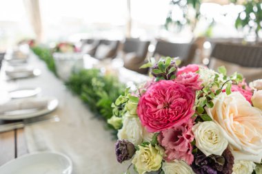 Pastel renklerde taze çiçek Aranjman parlak bir vurgu ile. Düğün arka plan. tablo bir restoranda. farklı ahşap masa üzerinde hafif bir vazoda Bahçe ve çalı gül çeşitleri