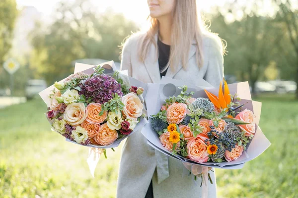 Two beautiful spring bouquet. Young girl holding a flowers arrangements with variety of colors. Violet, blue and peach color flower. Bright dawn or sunset sun — Stock Photo, Image