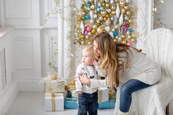 Mutlu aile portresi olarak ana sayfa - genç hamile anne küçük oğlunu kucaklar. Yeni Yılınız Kutlu Olsun. süslü Noel ağacı. Noel sabahı parlak oturma odasında. — Stok fotoğraf