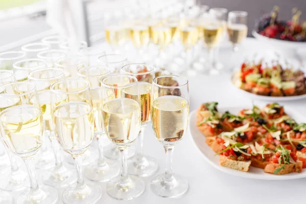 Lot of glasses champagne or wine on the table in restaurant. buffet table with lots of delicious snacks. — Stock Photo, Image