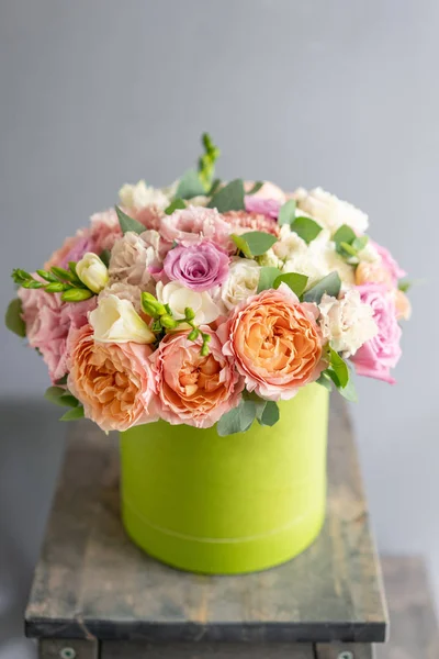 Beautiful spring bouquet in head box. Arrangement with mix flowers. The concept of a flower shop, a small family business. Work florist.