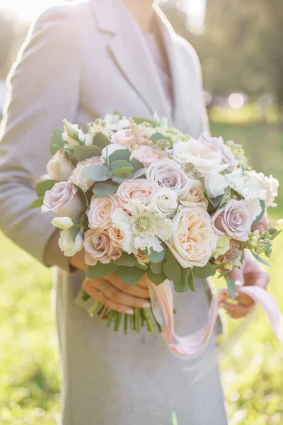 Весняний настрій. Молода дівчина тримає гарний весільний букет. квіткова композиція з білими і пастельними квітами. Яскравий світанок або захід сонця — стокове фото