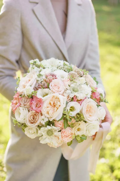 Весняний настрій. Молода дівчина тримає гарний весільний букет. квіткова композиція з рожевими і пастельними квітами. Яскравий світанок або захід сонця — стокове фото