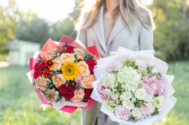 parlak ve hassas, pembe ve kırmızı, iki güzel buket. Bir çiçek düzenlemeleri ile renklerin çeşitli tutan genç kız. Parlak şafak veya günbatımı güneş
