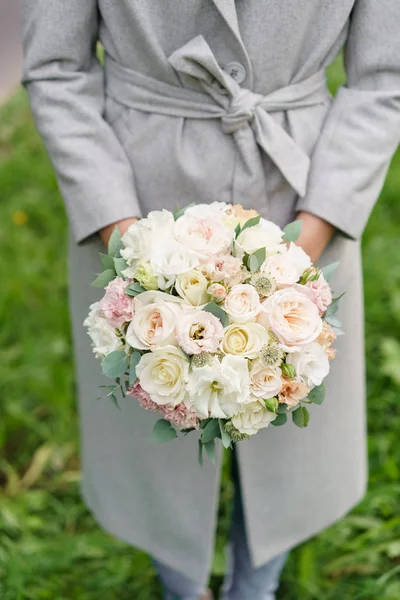 Весняний настрій. Молода дівчина тримає гарний весільний букет. квіткова композиція з білими і пастельними кольоровими квітами . — стокове фото