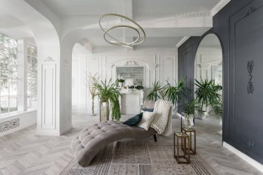 Sabah otelde lüks ışık iç. Lüks salon Parke ahşap zeminler, şömine, kanepe ve houseplant parlak ve temiz iç tasarımı. Duvarlarda sıva