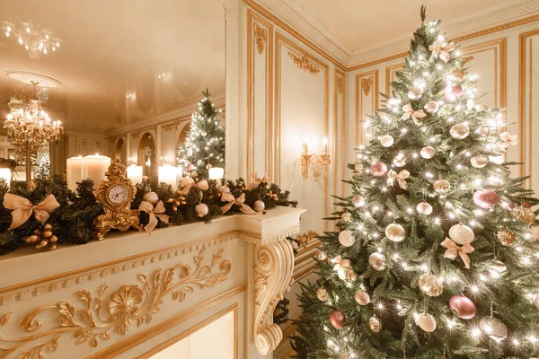 Interior clássico de um quarto branco. Noite de Natal à luz das velas. apartamentos clássicos com uma lareira branca, árvore de natal decorada, sofá, janelas grandes e lustre . — Fotografia de Stock