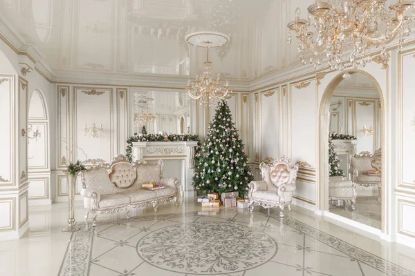 Dárky u vánočního stromu. Vánoční ráno. Klasické luxusní apartmány s bílým krbem, pohovkou, velkými okny a lustr. — Stock fotografie