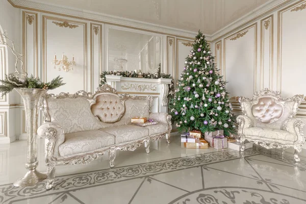 Weihnachtsmorgen. klassische luxuriöse Appartements mit weißem Kamin, geschmücktem Weihnachtsbaum, Sofa, großen Fenstern und Kronleuchter. — Stockfoto
