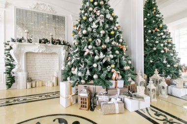 Noel Ağacı 'nın altında hediyeler ve hediye kutuları. Kurdeleli bej kutular. Yeni yıl dekore edilmiş ev içi. Kış Tatili konsepti.