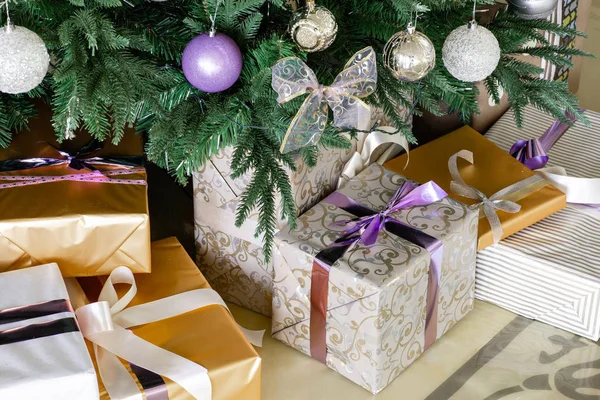 圣诞树下的礼物和礼品盒。带弓的盒子。新年装饰的房子内部。寒假理念. — 图库照片