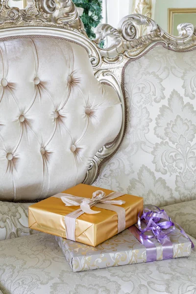 Regalos y cajas de regalo en el sofá. cajas con lazo de cinta. Año nuevo decorado interior de la casa. Concepto Winter Holiday . — Foto de Stock