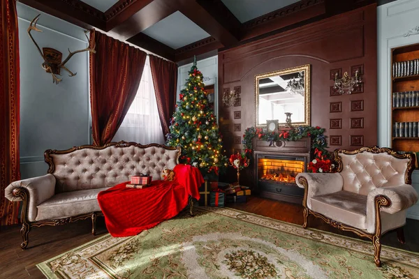 Mañana de Navidad. Regalos en el árbol de Navidad. Apartamentos clásicos con chimenea . —  Fotos de Stock