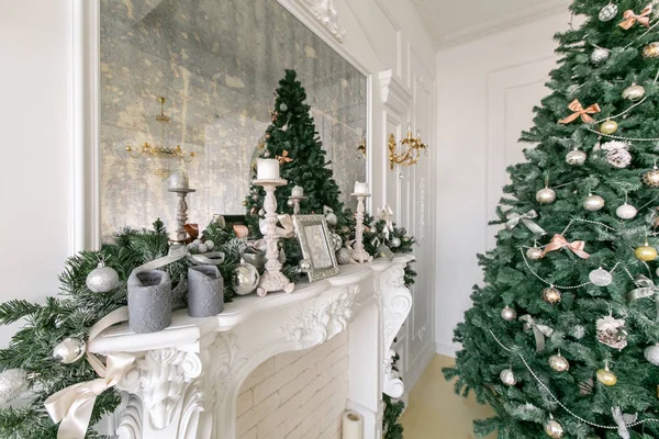 Weißer Kamin mit Kerzen und Tannenzweigen geschmückt. geschmückter Weihnachtsbaum. klassische Appartements, morgens im Hotel — Stockfoto