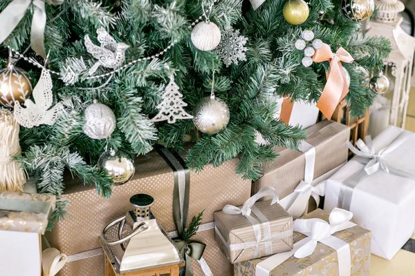 Cadeaux et coffrets cadeaux sous l'arbre de Noël. Boîtes beiges avec ruban papillon. Nouvelle année décorée intérieur de la maison. Concept vacances d'hiver. — Photo
