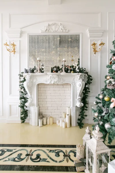 Chimenea blanca decorada con velas y ramas de abeto. Árbol de Navidad decorado. Apartamentos clásicos, mañana en el hotel — Foto de Stock