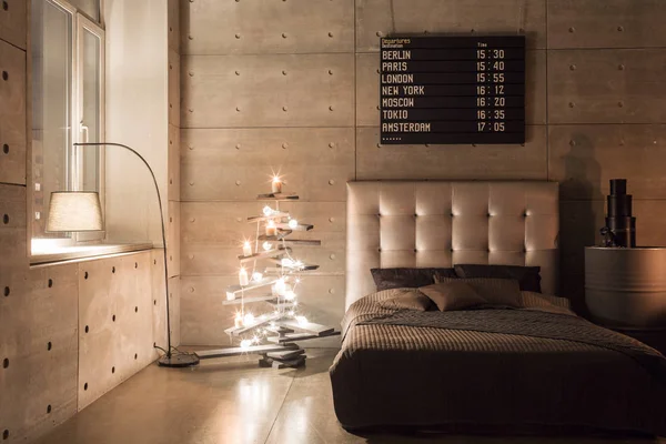 Moderní prázdná ložnice v podkroví stylu s šedé barvy a dřevěné ručně vyrobené vánoční stromeček s dárky. teplý a příjemný večer — Stock fotografie