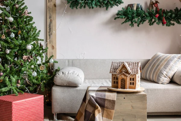 在早晨的客厅里的圣诞节。沙发床在圣诞节内饰。庆祝新年和假期。圣诞树和姜饼屋 — 图库照片