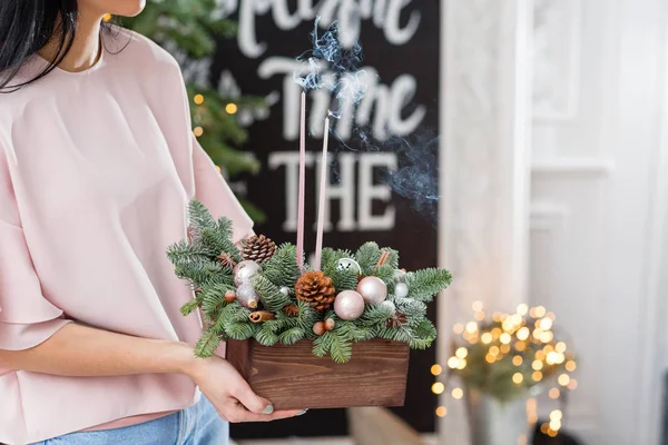 Apagar as velas e fumar. Oficina de decoração de Natal com suas próprias mãos. Caixa de madeira de Natal com ramos de abeto para o feriado. A celebração do ano novo . — Fotografia de Stock