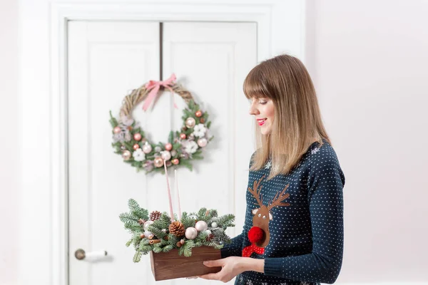 Młoda kobieta gospodarstwa Bożego Narodzenia, drewniane pudełko z gałęzi jodły na wakacje. Obchody nowego roku. — Zdjęcie stockowe