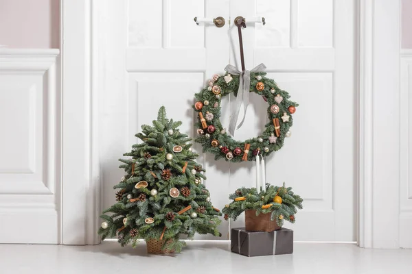 Decoração da casa antes das férias de ano novo. Conjunto de elementos decorativos com grinalda de ramos de abeto, árvore de Natal e arranjo em uma caixa de madeira — Fotografia de Stock