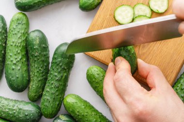 Detoks için salatalık su kesme eller mans. Üstten görünüm. Enerji kokteyl hazırlama süreci