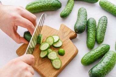 Detoks için salatalık su kesme eller mans. Üstten görünüm. Enerji kokteyl hazırlama süreci