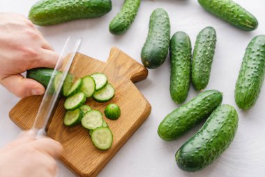 Detoks için salatalık su kesme eller mans. Üstten görünüm. Enerji kokteyl hazırlama süreci