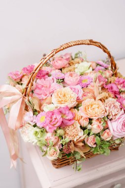 çiçek düzenleme çeşitli renklerde hasır sepet pembe tablo ile. güzel bahar buket. parlak oda, beyaz duvar. kopya alanı
