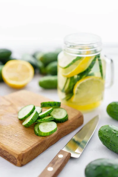 Zaměřit se na plátky okurky. Letní koktejl okurka limonáda. Osvěžující voda s okurkou, máta a citron na šedém pozadí. Zdravý nápoj a detoxikační koncept. Kopírovat prostor — Stock fotografie