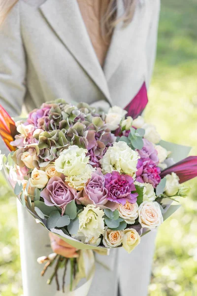 Young girl holding a beautiful spring bouquet. flower arrangement with hydrangea and garden roses. Bright dawn or sunset sun — Stock Photo, Image