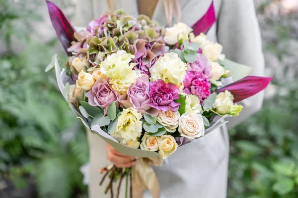 güzel bahar buket. Çeşitli renk çiçek aranjmanı tutan genç kız. Park, yaprakları ve arka plan üzerinde bulanık