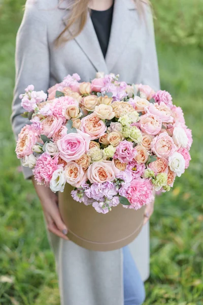 Hermoso ramo de primavera en caja redonda. Arreglo con varias flores. El concepto de una floristería. Un conjunto de fotos para un sitio o catálogo. Floristería de trabajo. — Foto de Stock