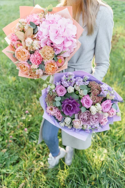 Dois belos buquê de primavera. Menina segurando um arranjos de flores com várias cores. Amanhecer brilhante ou pôr do sol — Fotografia de Stock