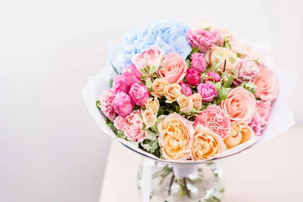 Krásný jarní kytice. květiny uspořádání s různými barev do vázy na stůl růžová. světlé místnosti, bílá stěna. kopie prostor — Stock fotografie