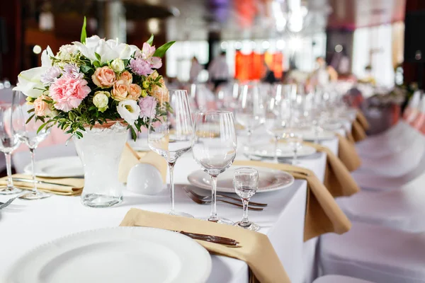 Táblázat egy luxus esküvői fogadás. Gyönyörű virágok az asztalra. Ételeket szolgálnak fel, üveg szemüveg, pincérek munka, — Stock Fotó