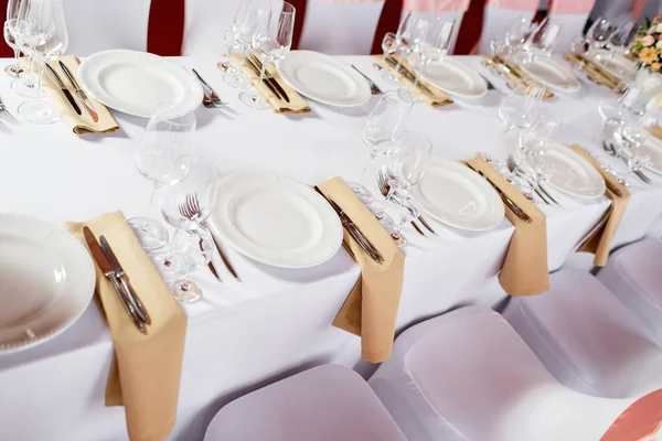 Mesa en una recepción de boda de lujo. Hermosas flores en la mesa. Sirve platos, vasos de vidrio, camareros trabajan , — Foto de Stock