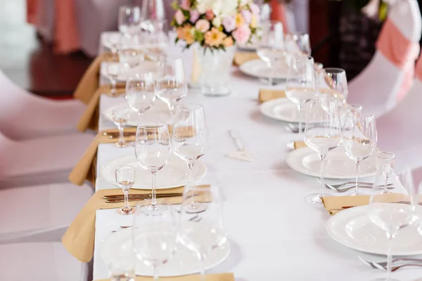 Táblázat egy luxus esküvői fogadás. Gyönyörű virágok az asztalra. Ételeket szolgálnak fel, üveg szemüveg, pincérek munka, — Stock Fotó