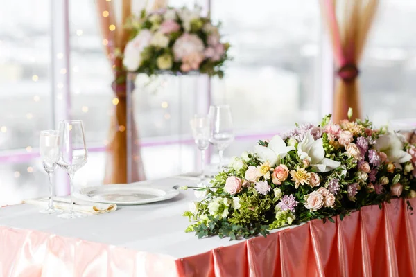 La mesa de los recién casados. Ajuste de mesa en una recepción de boda de lujo. Hermosas flores sobre la mesa . — Foto de Stock