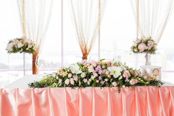 La mesa de los recién casados. Ajuste de mesa en una recepción de boda de lujo. Hermosas flores sobre la mesa . — Foto de Stock