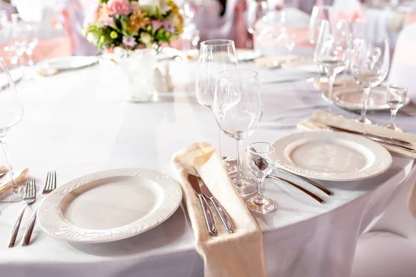 Okrągły stół na przyjęcie weselne luksusowych. Piękne kwiaty na stole. Serwujemy dania kuchni, okulary szkła, kelnerzy pracy, — Zdjęcie stockowe