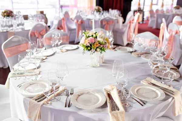 Mesa redonda en una recepción de boda de lujo. Hermosas flores en la mesa. Sirve platos, vasos de vidrio, camareros trabajan , — Foto de Stock