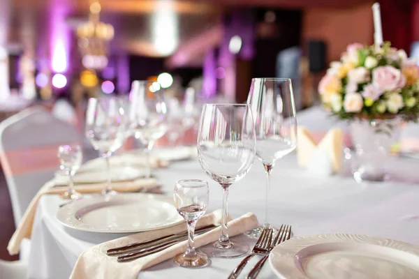 Mesa redonda en una recepción de boda de lujo. Hermosas flores en la mesa. Sirve platos, vasos de vidrio, camareros trabajan , — Foto de Stock