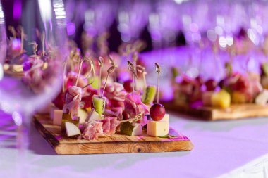 Açık büfedeki tabakta hafif atıştırmalıklar. Çeşitli küçük kanepeler, atıştırmalıklar, etkinliklerde restoran yemekleri. Bir gala resepsiyonu. Parti malzemeleri için süslenmiş nefis bir masa..