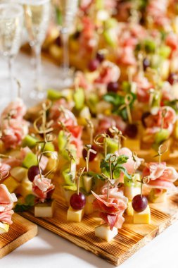 Açık büfedeki tabakta hafif atıştırmalıklar. Çeşitli küçük kanepeler, atıştırmalıklar, etkinliklerde restoran yemekleri. Bir gala resepsiyonu. Parti malzemeleri için süslenmiş nefis bir masa..