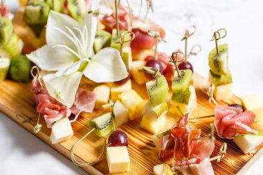 Açık büfedeki tabakta hafif atıştırmalıklar. Çeşitli küçük kanepeler, atıştırmalıklar, etkinliklerde restoran yemekleri. Bir gala resepsiyonu. Parti malzemeleri için süslenmiş nefis bir masa..