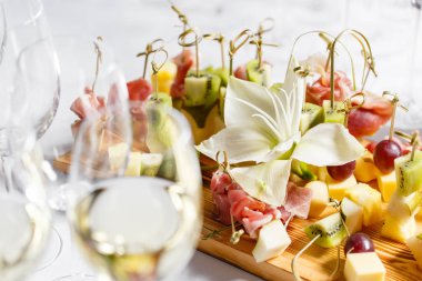 Resepsiyon büfedeki. Kanepeler ahşap tahta üzerinde ürün yelpazesine. Ziyafet Servisi. Gıda catering, peynir, jamon, prosciutto ve meyve ile aperatifler