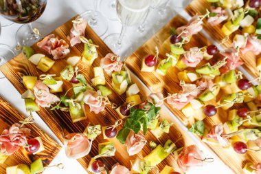 Açık büfedeki tabakta hafif atıştırmalıklar. Çeşitli küçük kanepeler, atıştırmalıklar, etkinliklerde restoran yemekleri. Bir gala resepsiyonu. Parti malzemeleri için süslenmiş nefis bir masa..