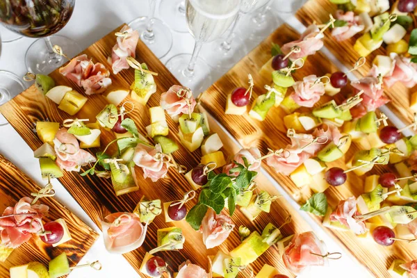 Açık büfedeki tabakta hafif atıştırmalıklar. Çeşitli küçük kanepeler, atıştırmalıklar, etkinliklerde restoran yemekleri. Bir gala resepsiyonu. Parti malzemeleri için süslenmiş nefis bir masa..